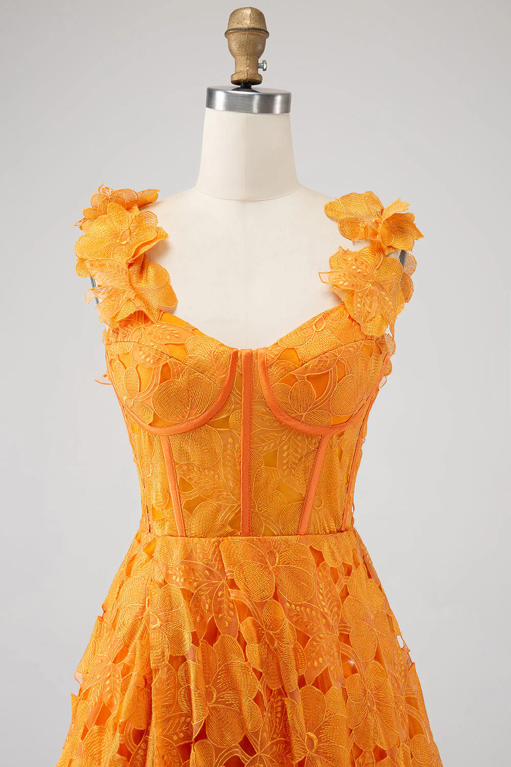 Close-up of floral lace detail on an orange A-line prom dress.