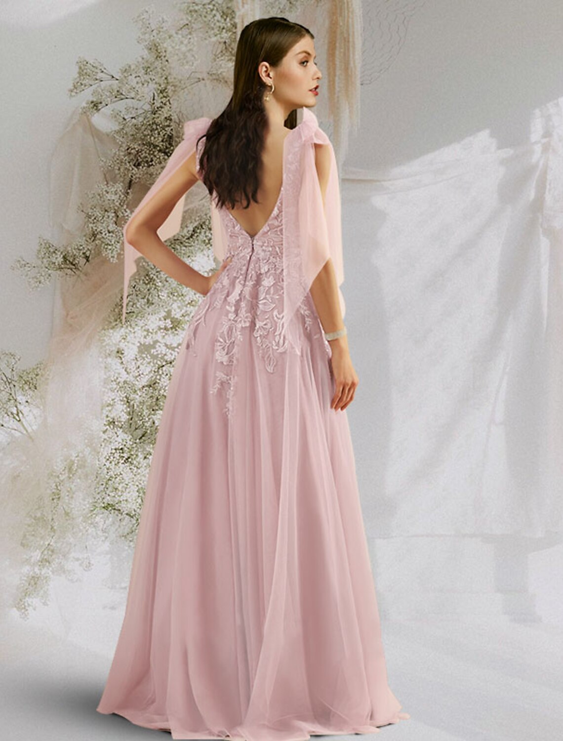 Open back of a tulle prom dress with bow details.