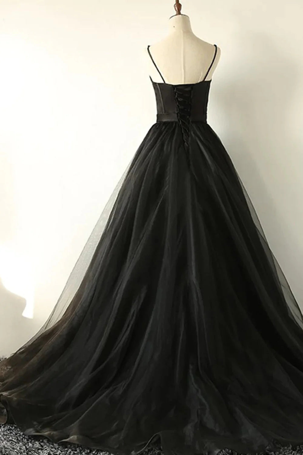 Black A-line tulle prom dress, side view, showing flowy skirt.