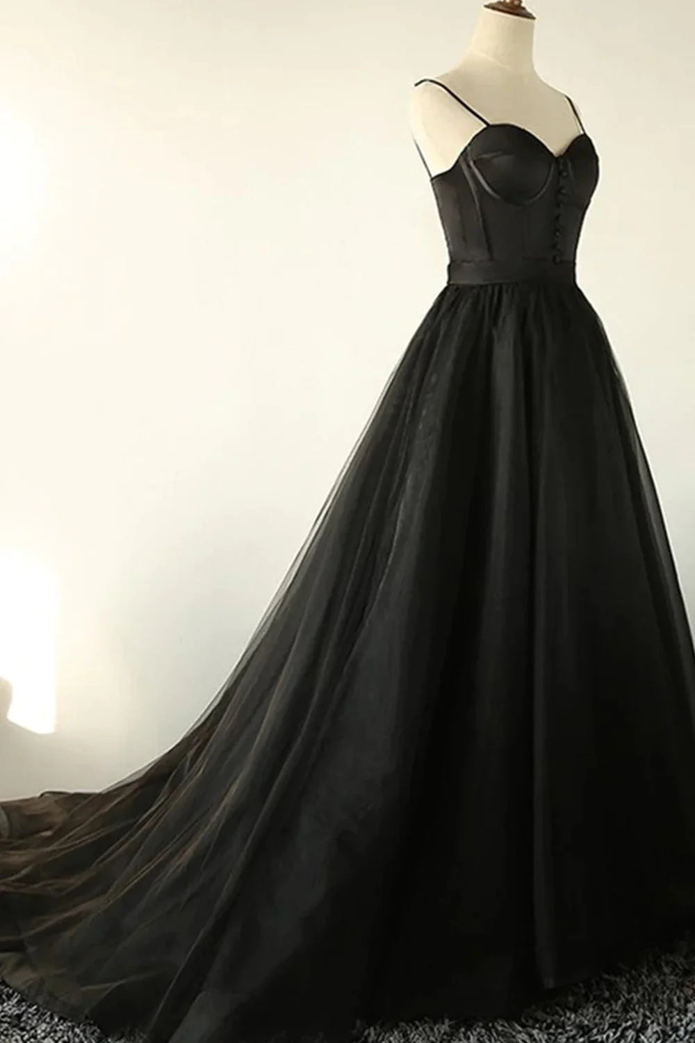 Close-up of the black A-line tulle prom dress, highlighting the V-neck and fabric.