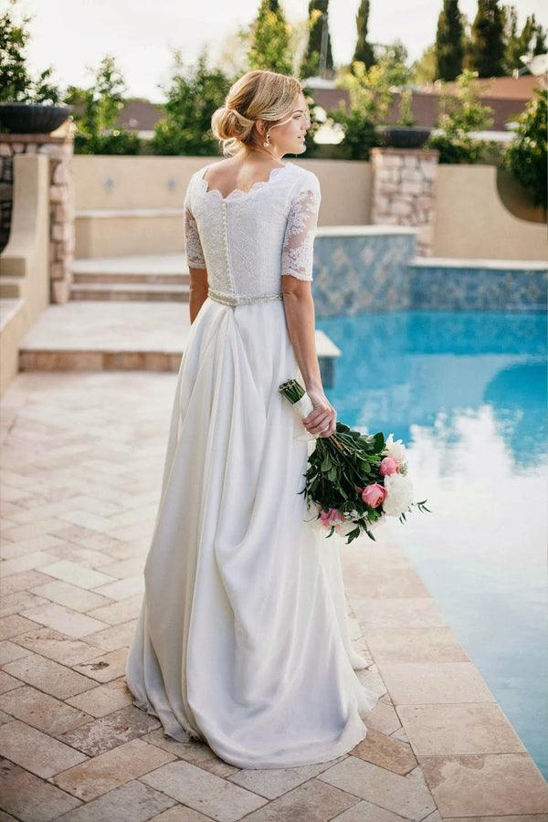 Back view of an elegant ivory bridal gown, showcasing the intricate lace and flowing A-line skirt.