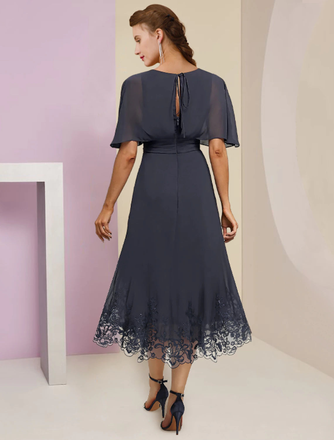 Back view of A-line formal dress featuring lace details and crystal brooch.