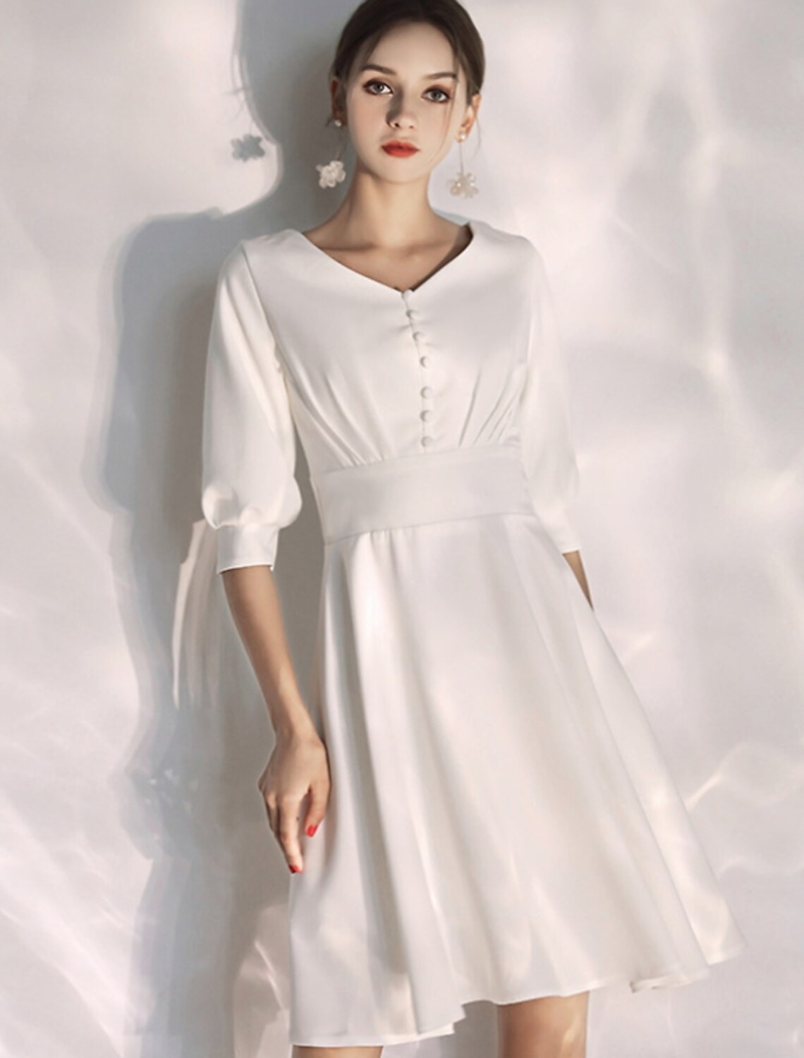 Model wearing an elegant A-line V-neck little white reception wedding dress with half sleeves.