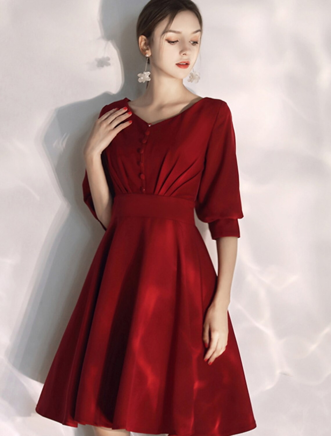 Side view of a model in a knee-length A-line white wedding dress, showcasing the half sleeves.