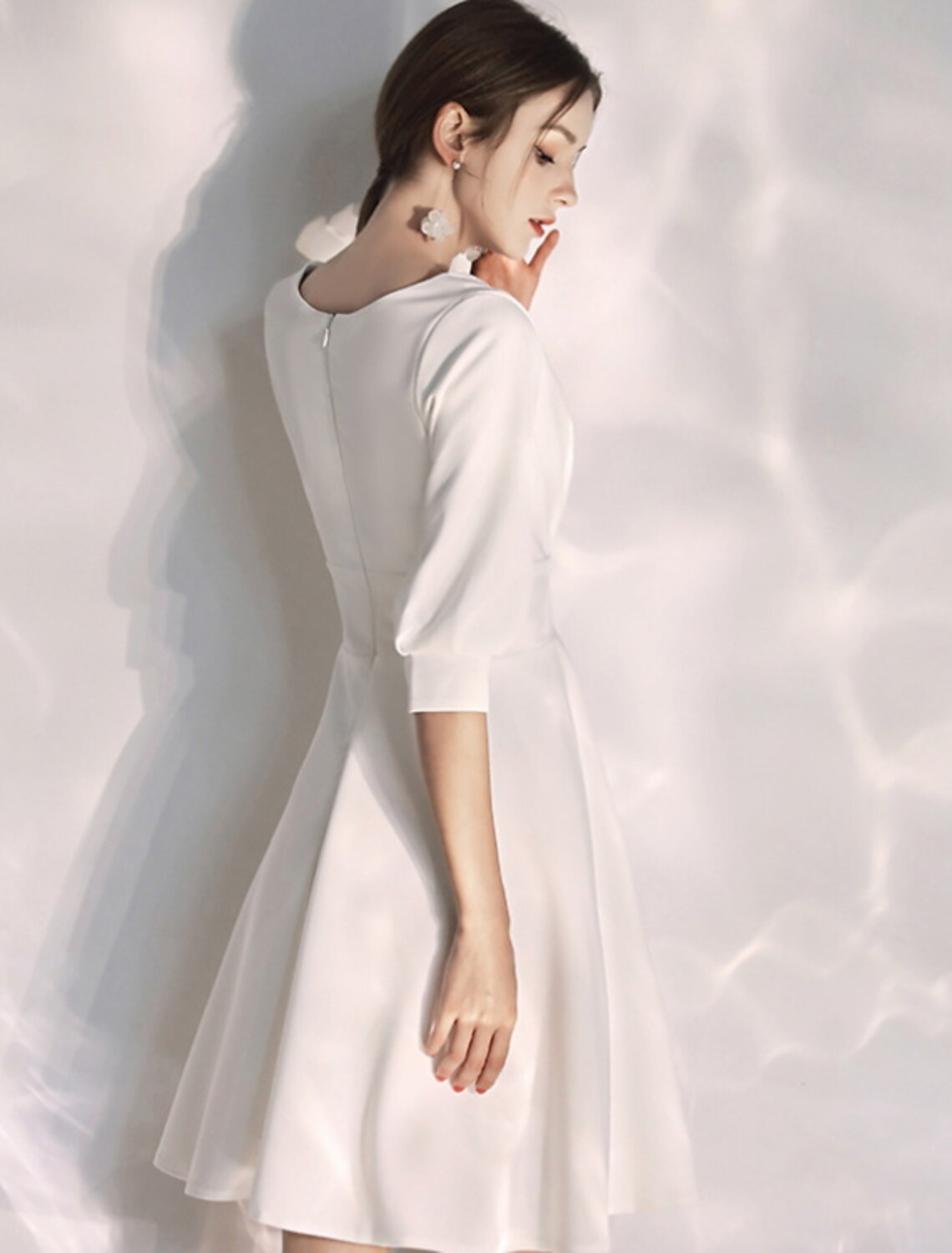 Back view of the little white reception dress, highlighting the A-line silhouette.