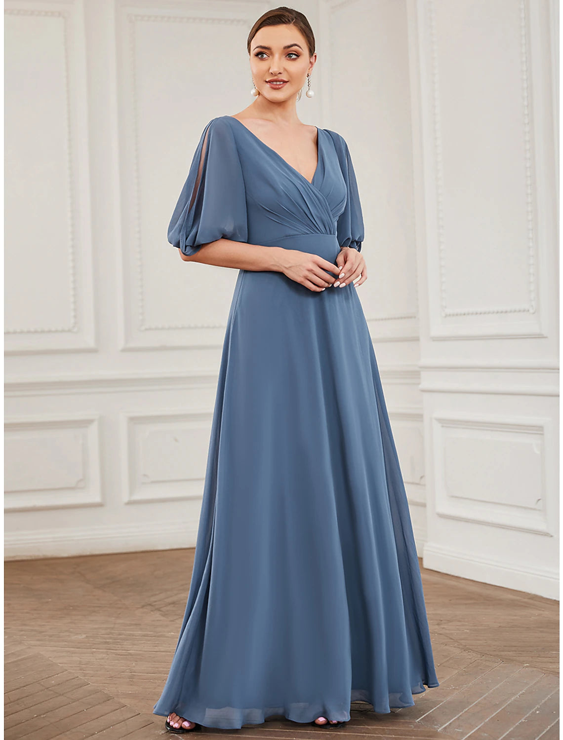 Woman wearing an elegant A-line V-neck half sleeve chiffon pleated floor length evening gown.