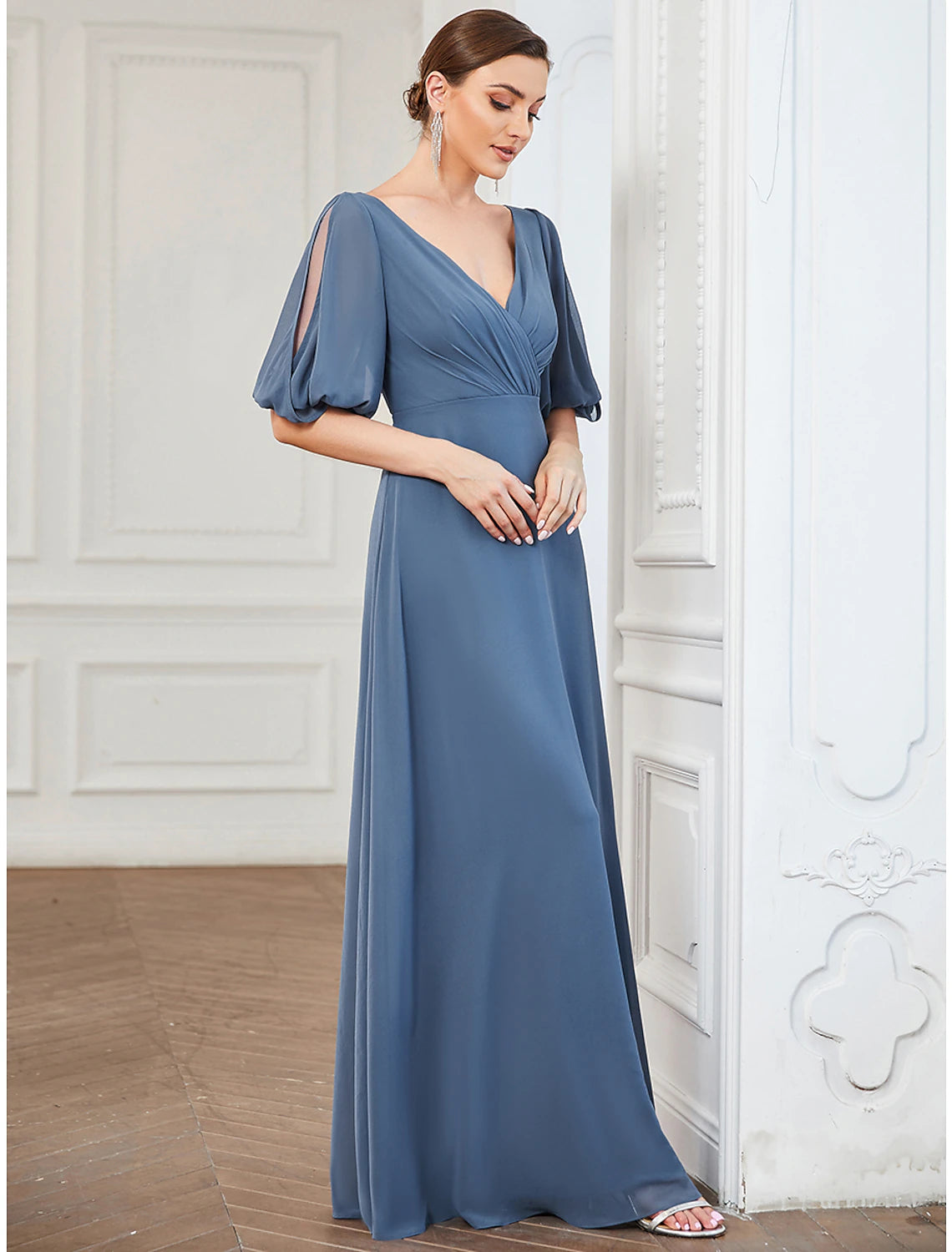 Woman walking in a flowy A-line pleated chiffon floor length dress.