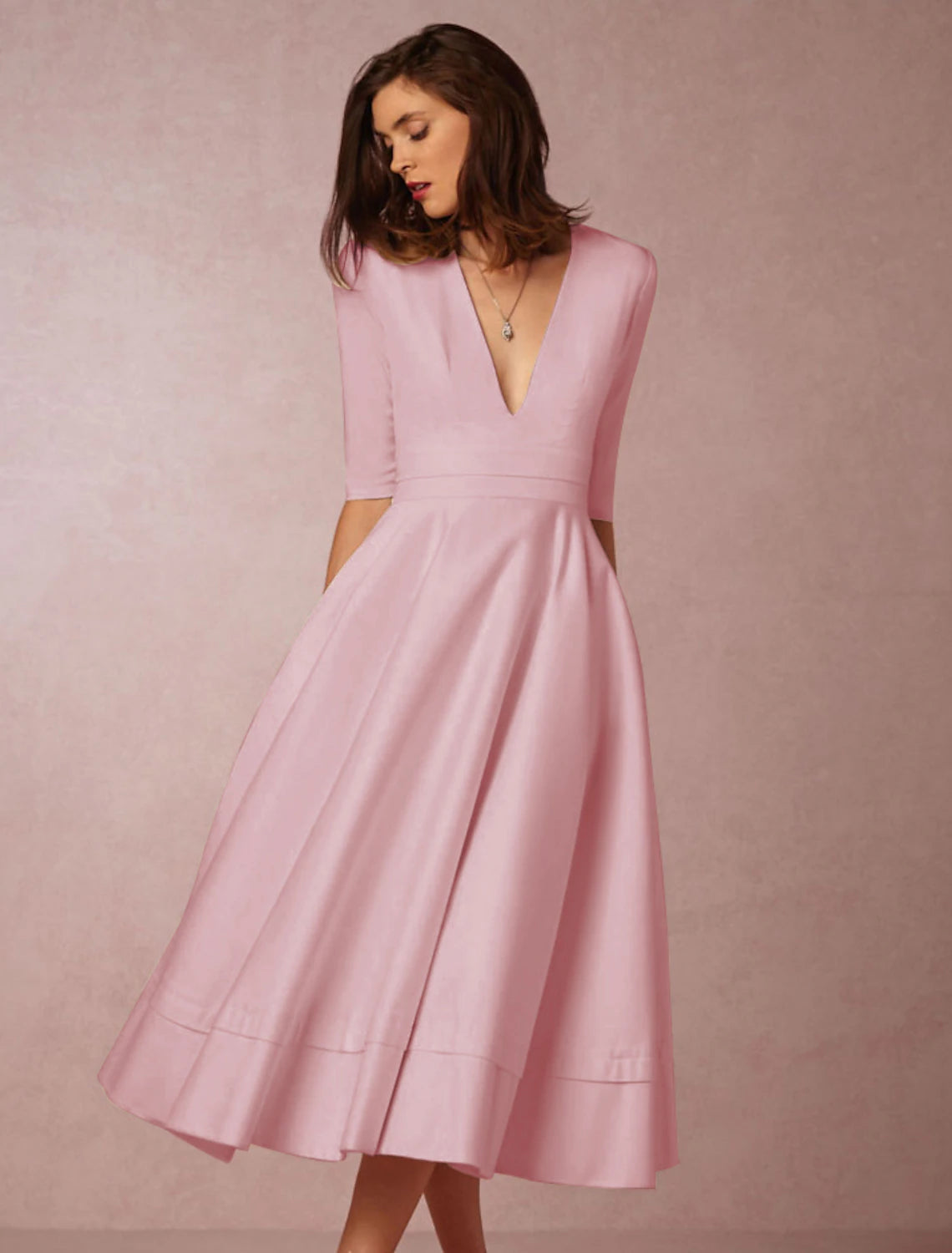 Woman wearing a white A-Line tea length dress with V-neck.