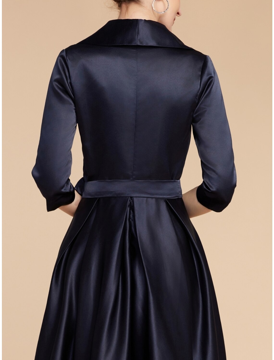 Close-up of the V-neckline and ruched bodice of the satin dress.