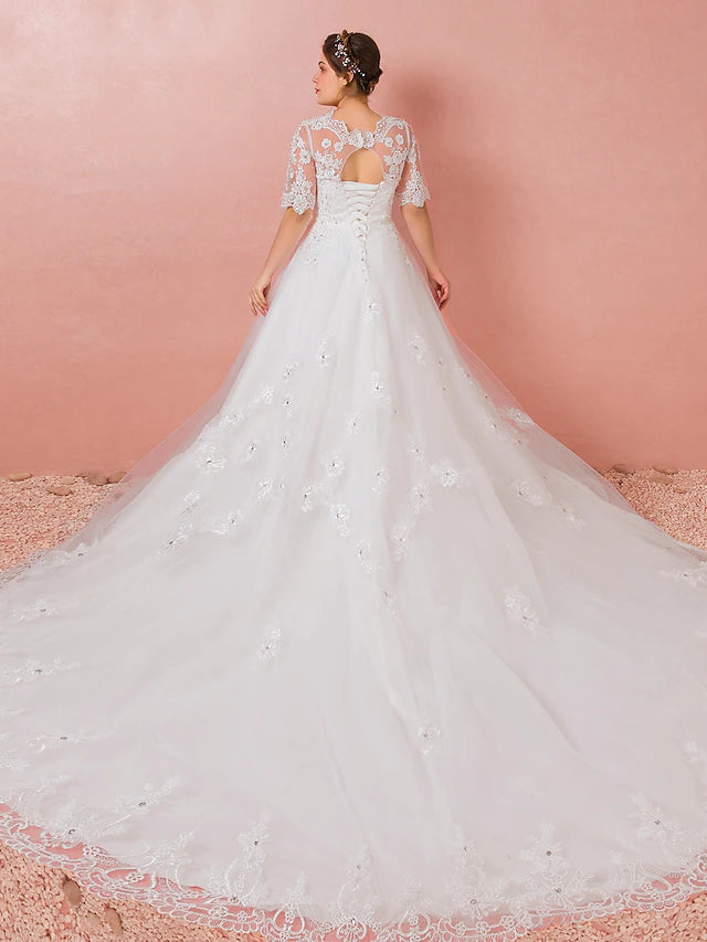 Back view of a wedding dress showing cathedral train and lace details.
