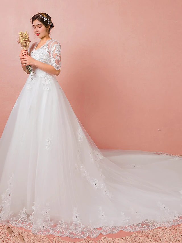 Close-up of lace and crystal embellishments on a satin wedding dress.
