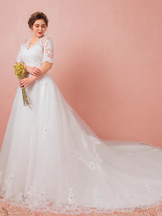 Full length view of a wedding dress with a flowing cathedral train.