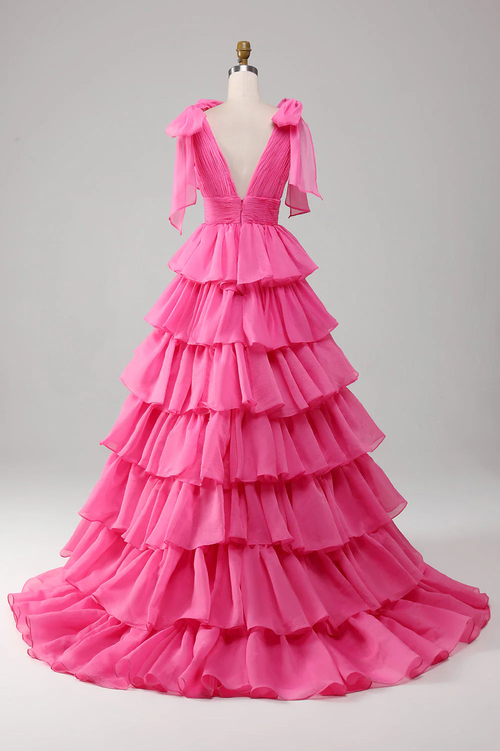Model posing in a fuchsia A-line V-neck prom dress, showing the flowing skirt.