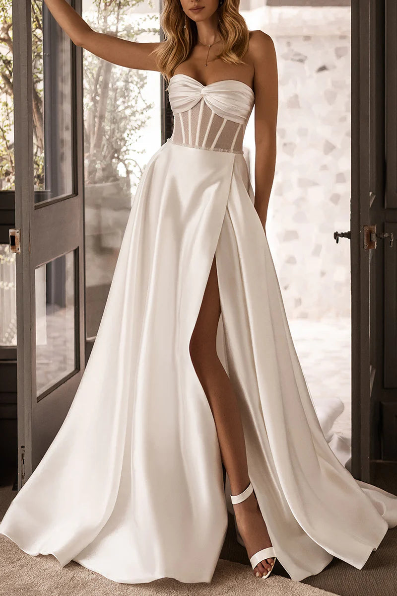 Woman in an elegant white A-line satin wedding dress with a high split.