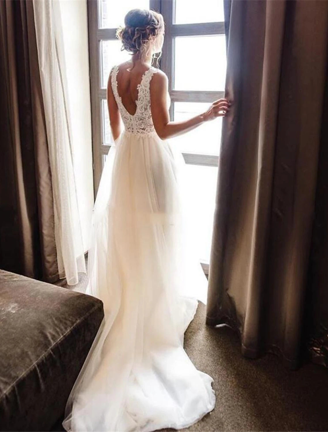 Side view of a bride wearing a sleeveless A-line wedding gown.