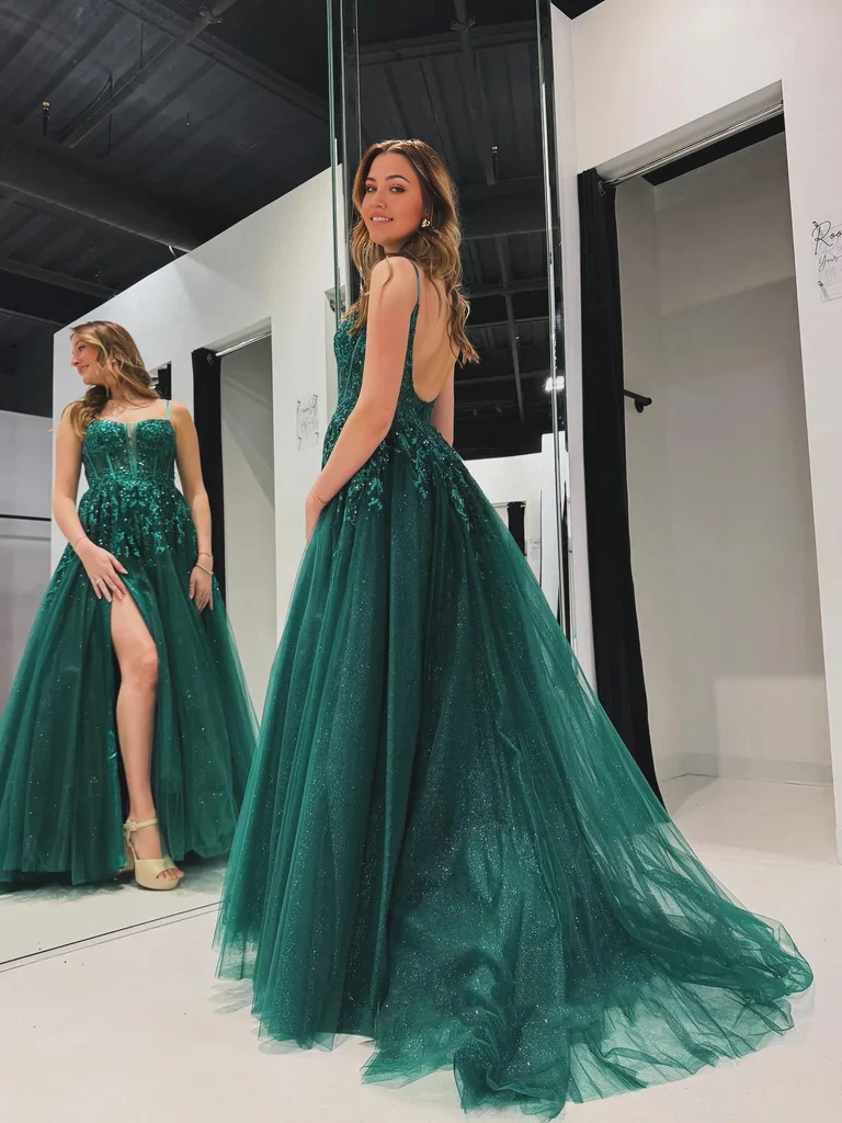 Side view of a woman in a long A-line V-neck lace prom dress.