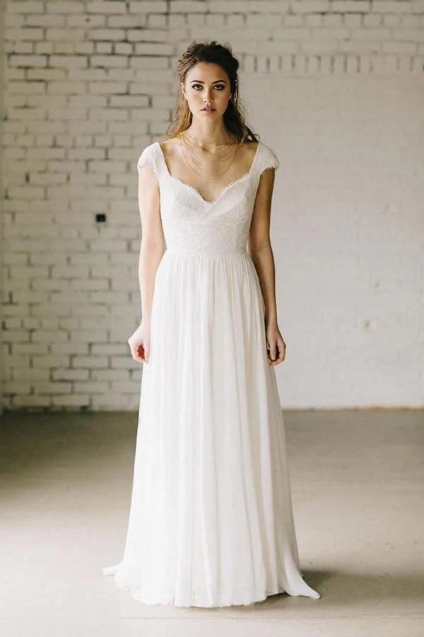 Model wearing an A-Line lace cap sleeve ivory chiffon wedding dress, front view.