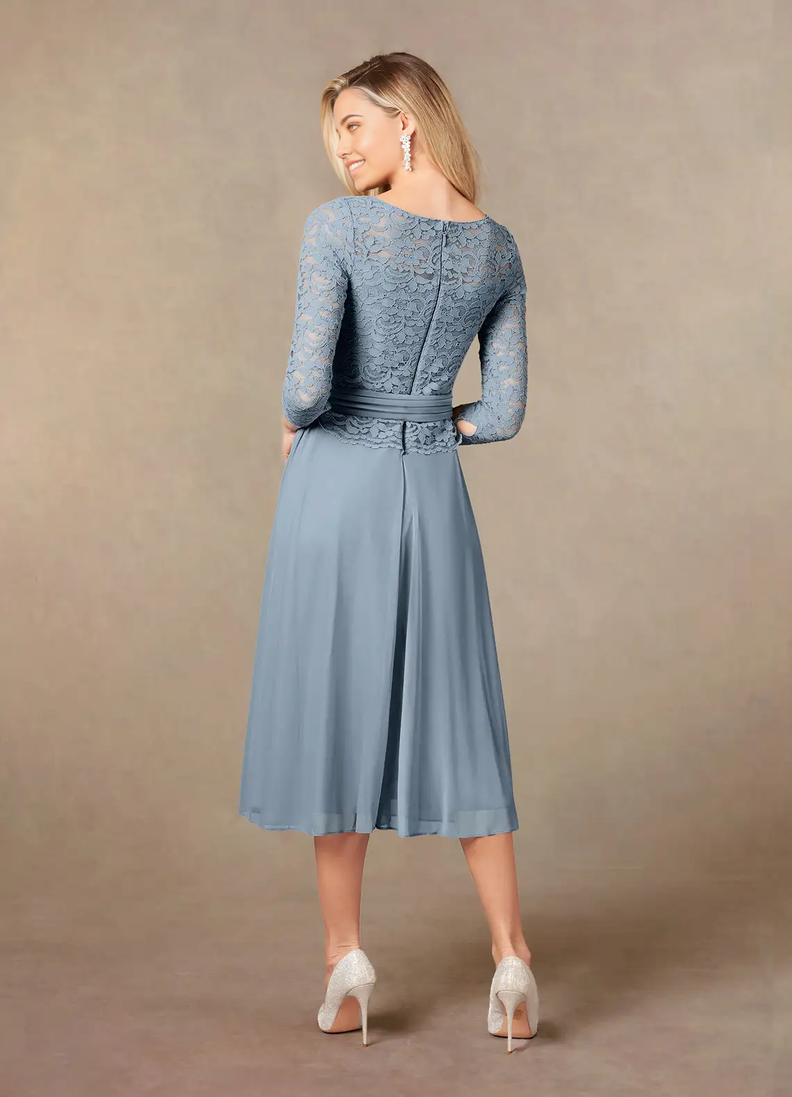 Woman wearing a dusty blue lace Mother of the Bride dress, side view.