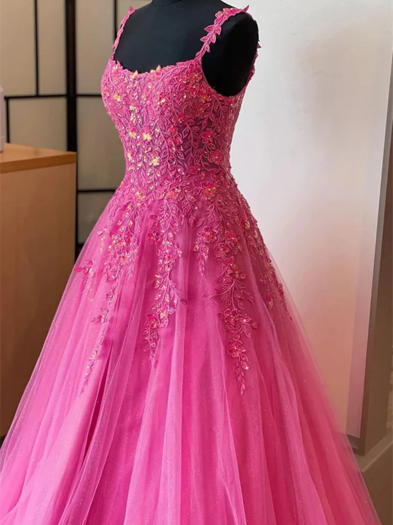 Woman wearing a long A-line V-neck prom dress with delicate lace and tulle details.
