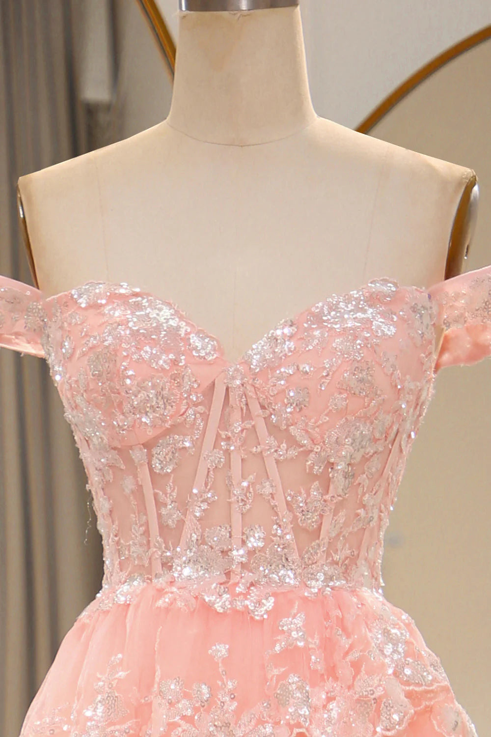 Back view of the elegant blush A-line prom dress, showcasing the flowing tiered design.