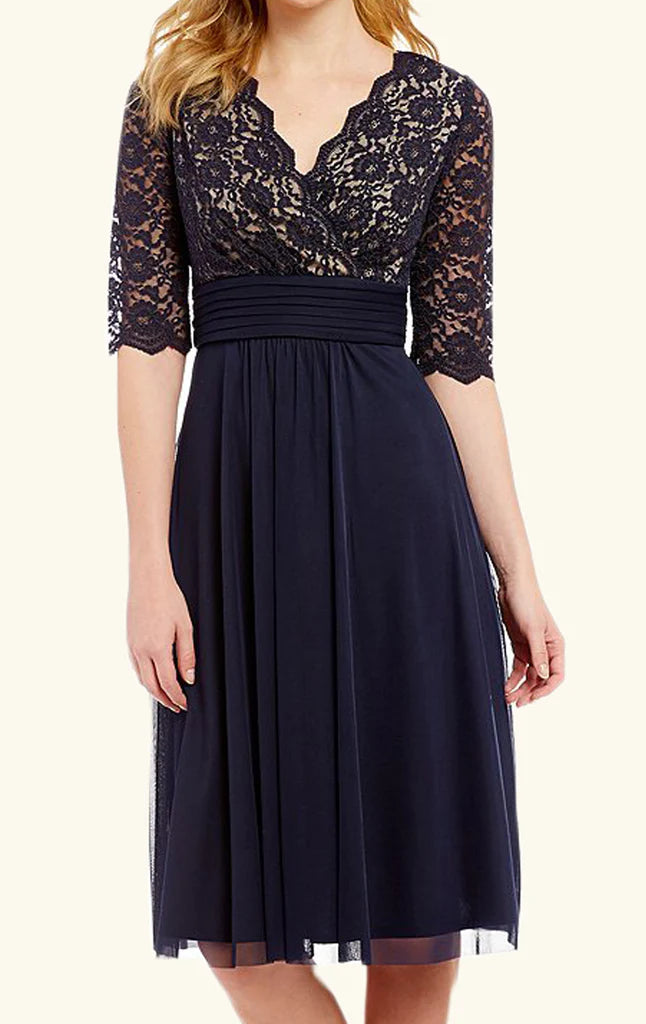 Woman wearing an elegant A-line V-neck lace Mother of the Bride dress with short sleeves.