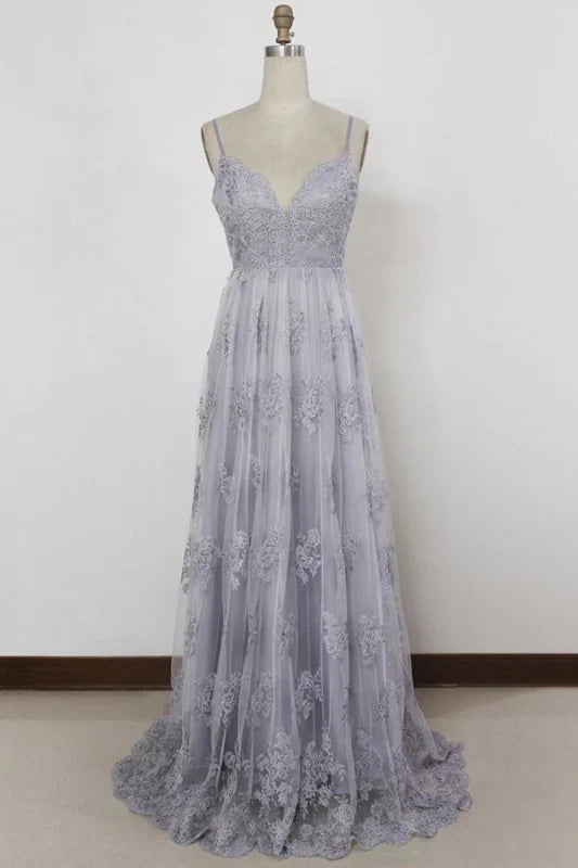 Woman wearing an elegant A-line lace gown with spaghetti straps and V-neckline.