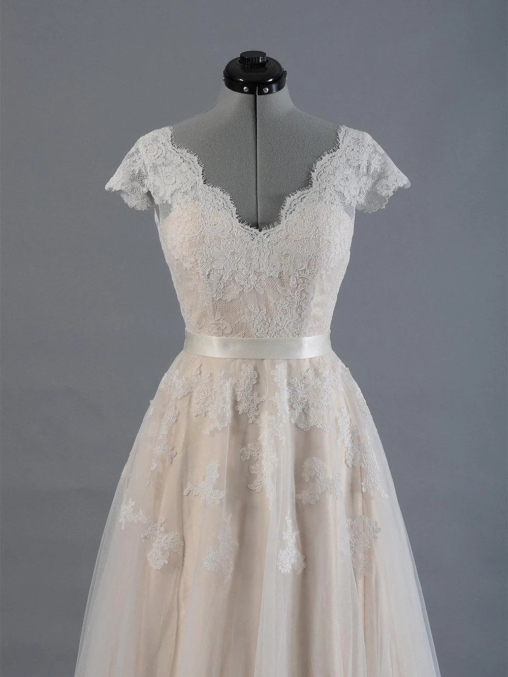 Full length V-neck bridal gown with flowing tulle skirt.