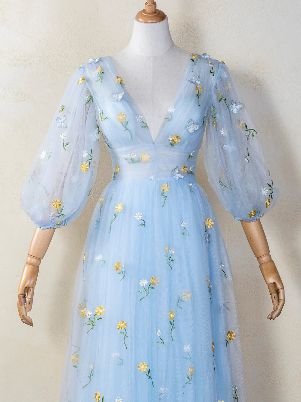 Full view of a woman wearing a flowing blue tulle prom dress.