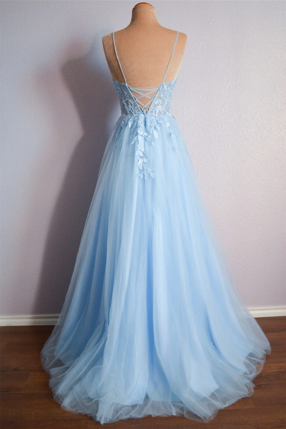 Back view of a long tulle prom dress showing lace-up detail and appliques.