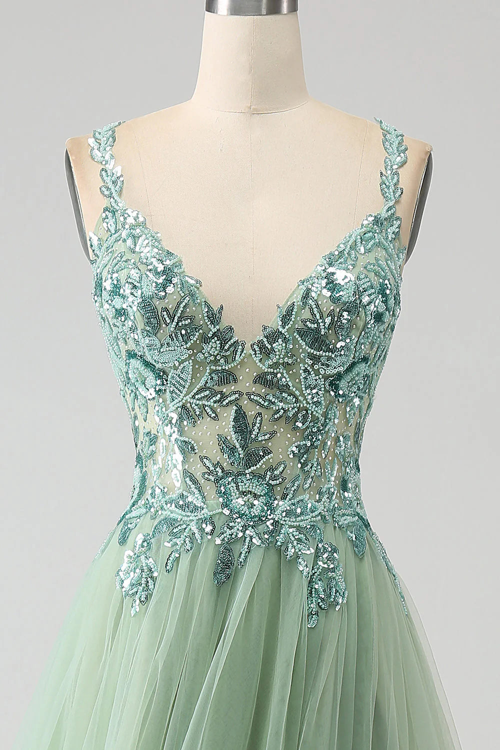 Close-up of the delicate appliques on a light green A-line V-neck long prom dress.