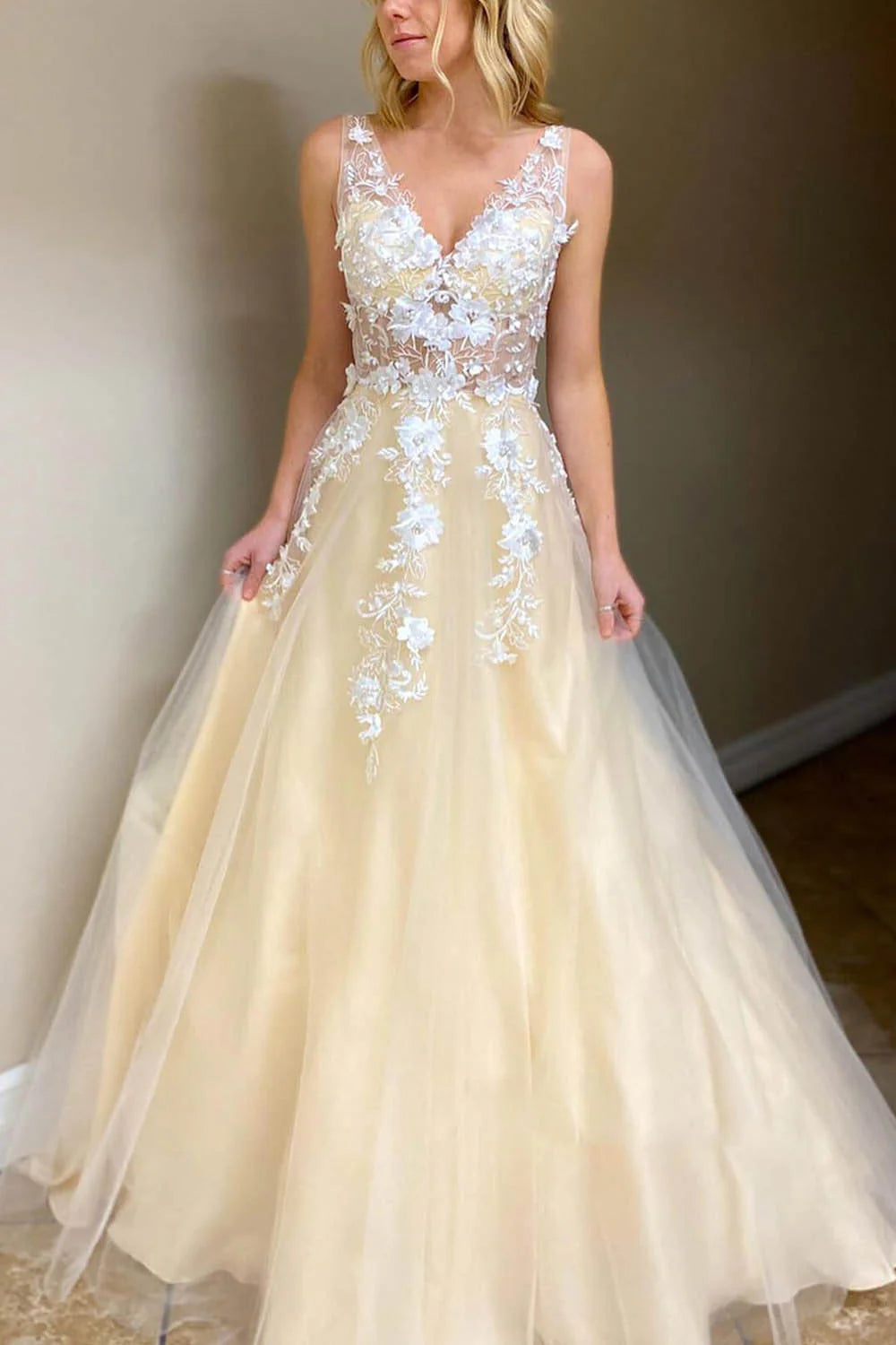 Elegant A-line V-neck long prom dress with delicate appliques, worn by a model.