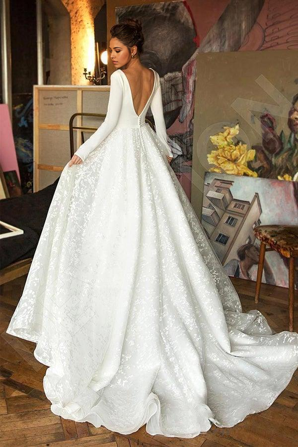 Back view of a flowing A-line bridal gown with long sleeves.