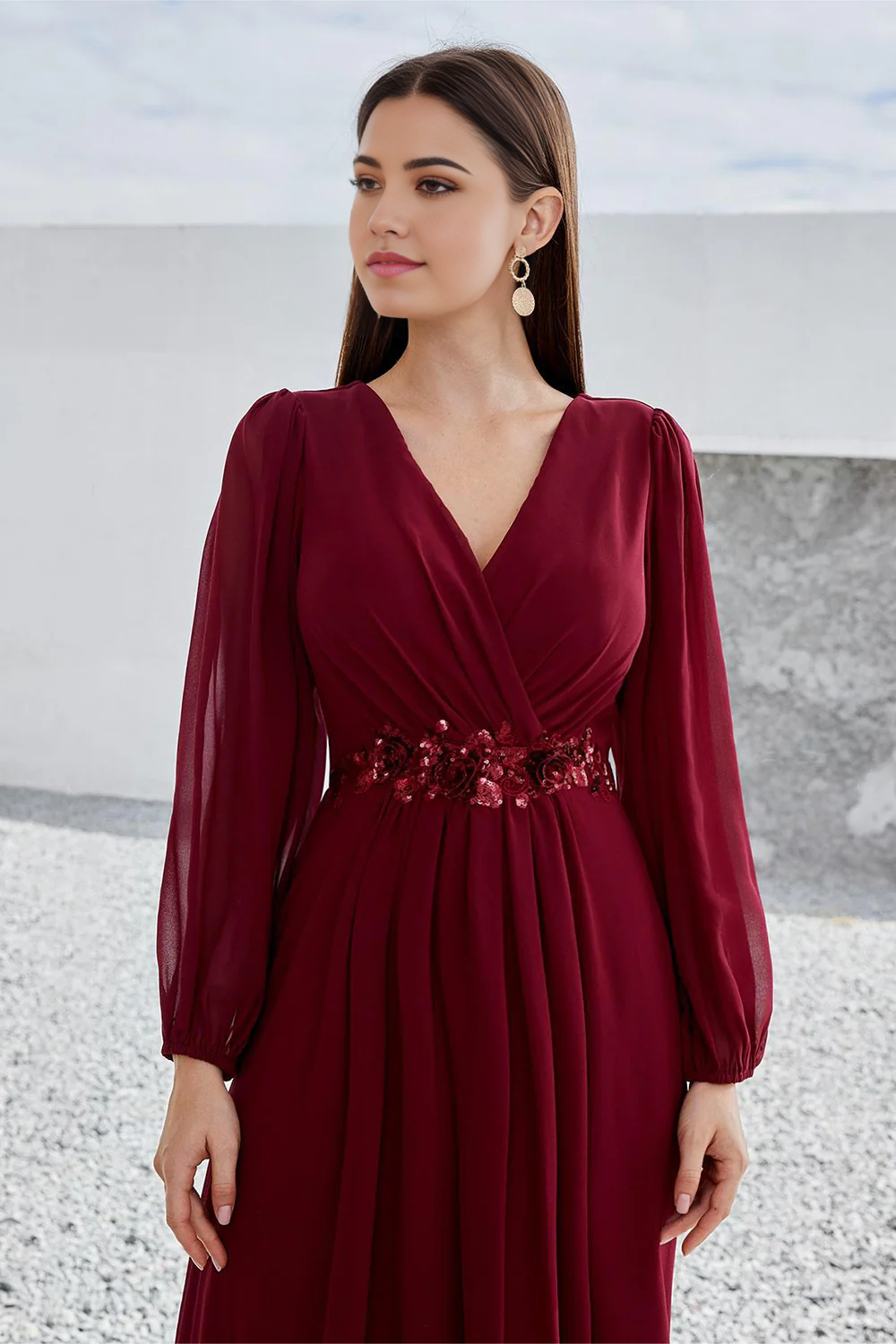Close-up of the fabric and V-neckline on a burgundy formal dress.