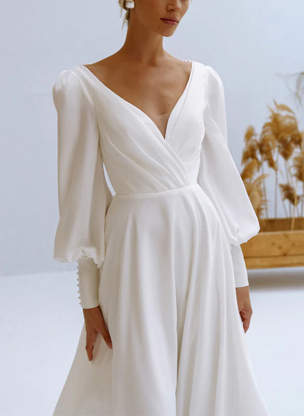 Bride wearing an A-line V-neck long sleeve chiffon wedding dress.