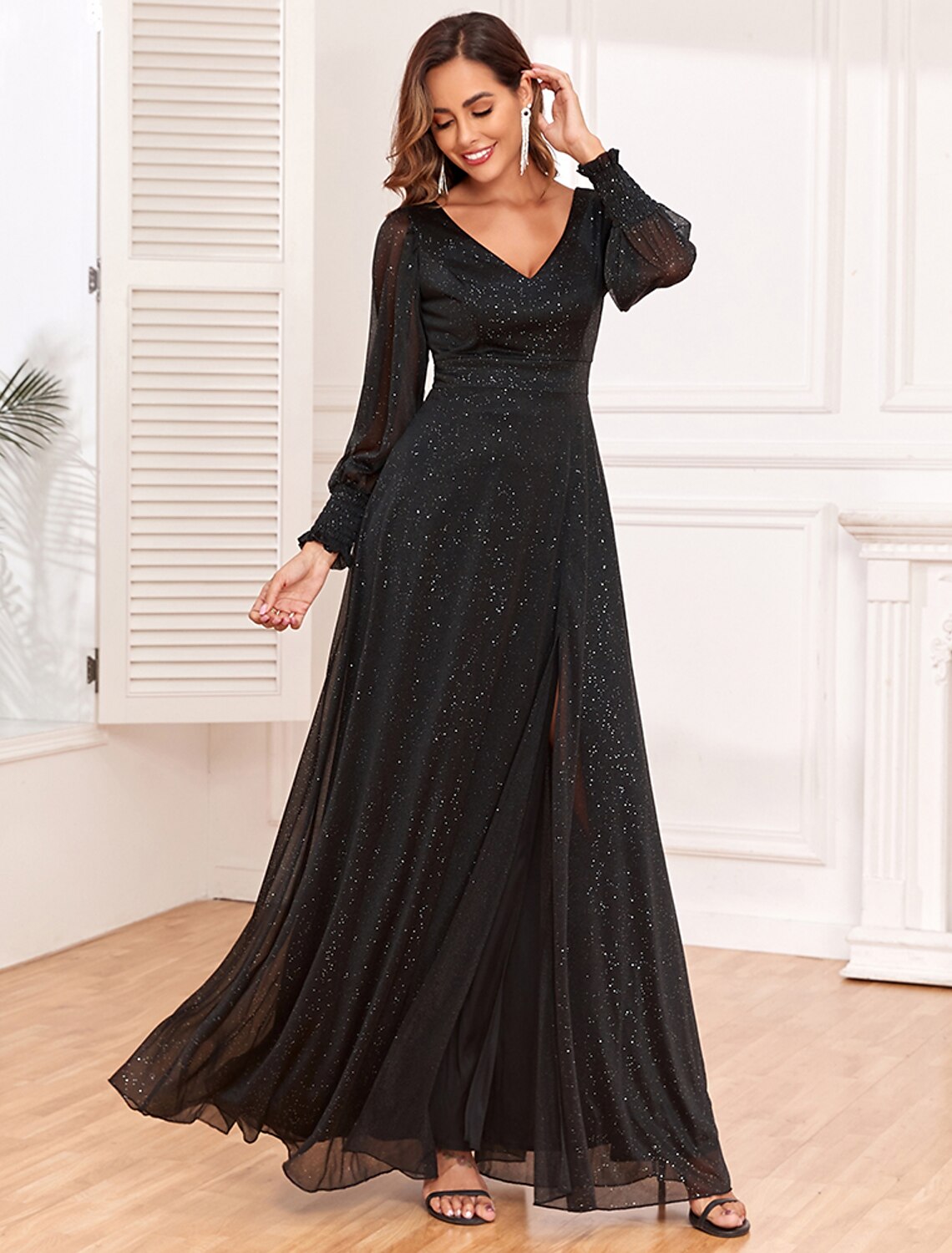 Model posing gracefully in the black glitter A-line gown, showing its elegant drape.