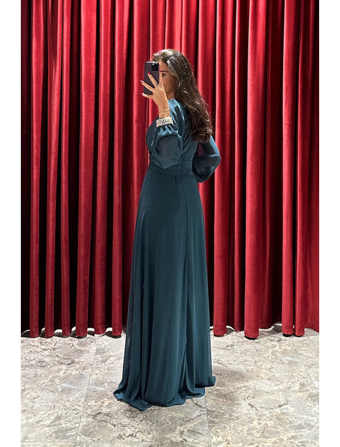 Close-up of the V-neckline and long sleeves of the evening gown.
