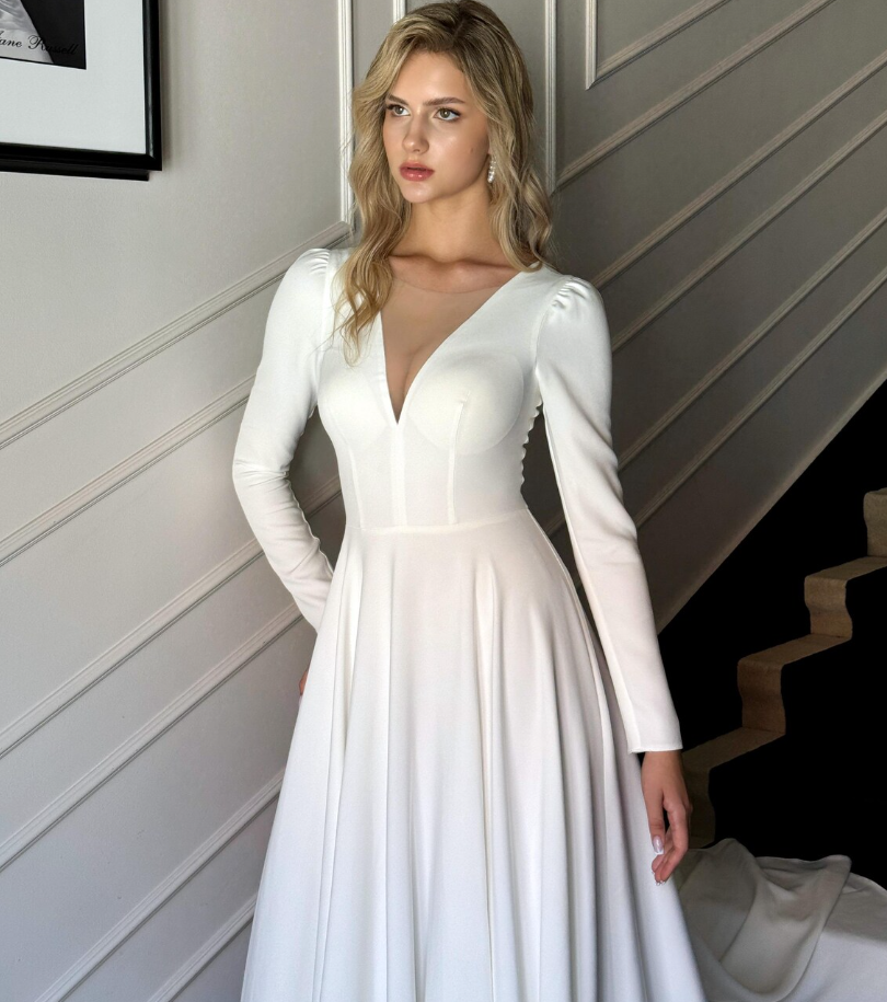 Side view of a bride wearing a modest long sleeve wedding dress with a V-neck.