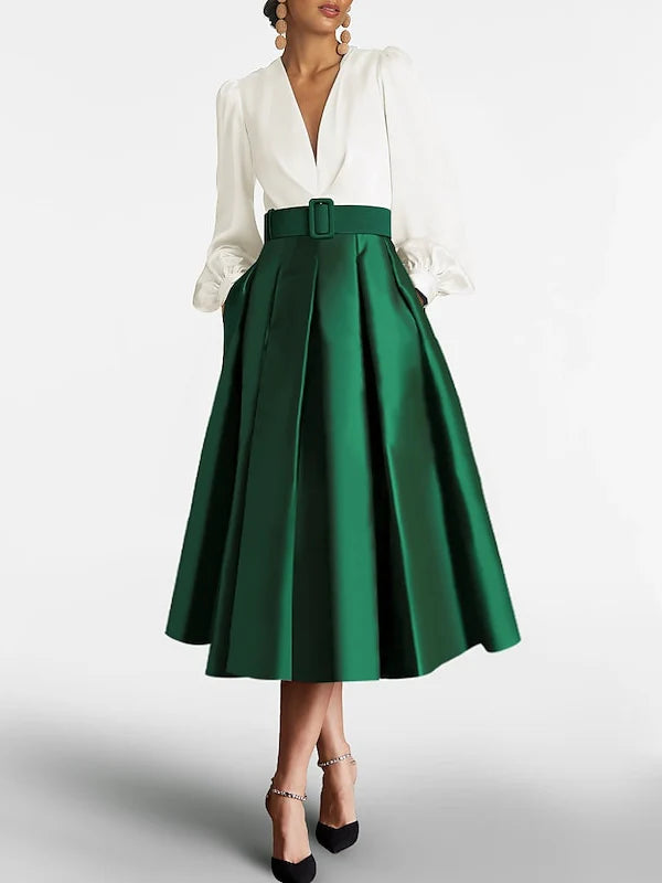 Woman wearing an elegant dark A-line V-neck long sleeve knee-length dress, suitable for a mother of the bride.