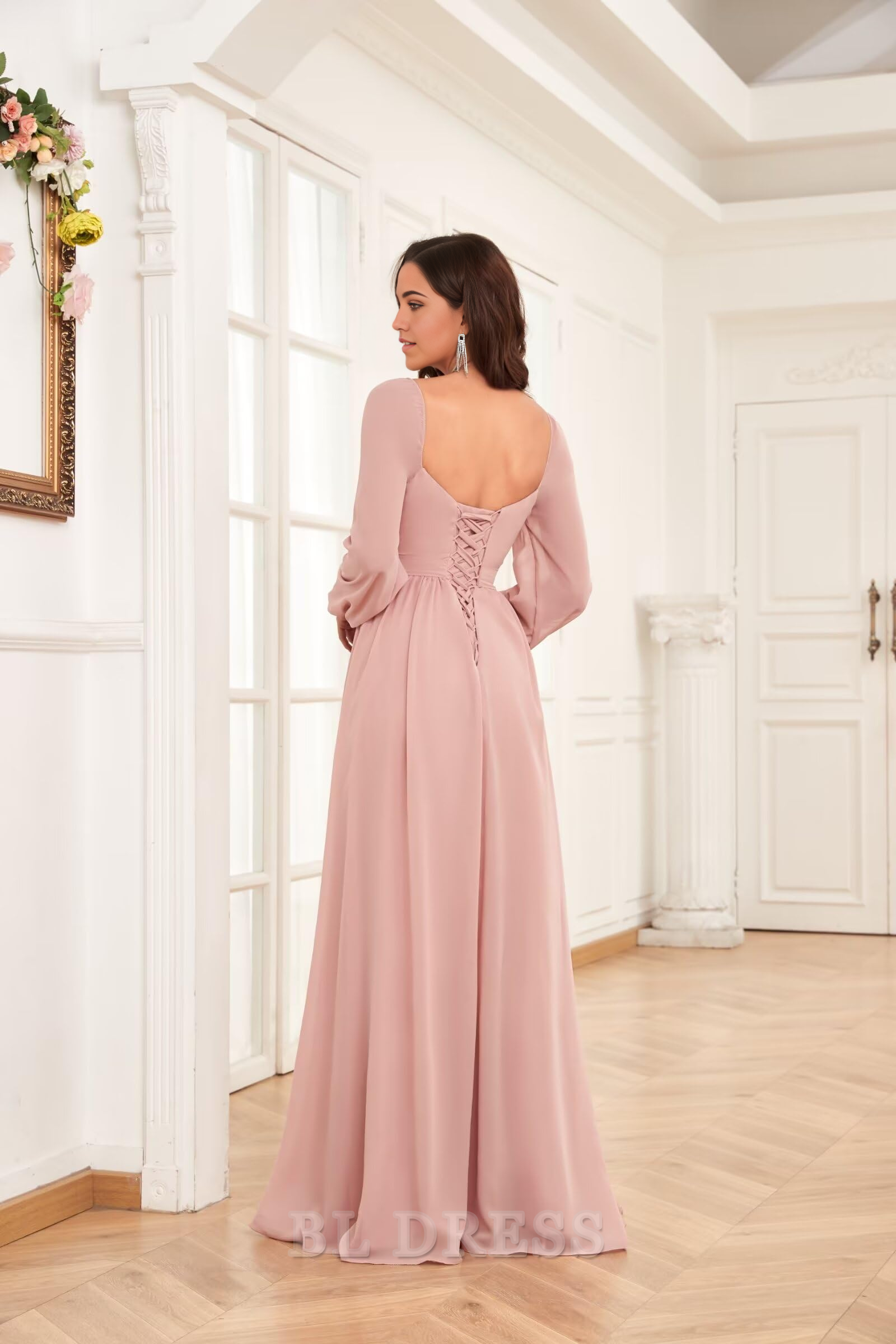 Back view of a model in a pleated chiffon formal dress, showcasing the flowing fabric.