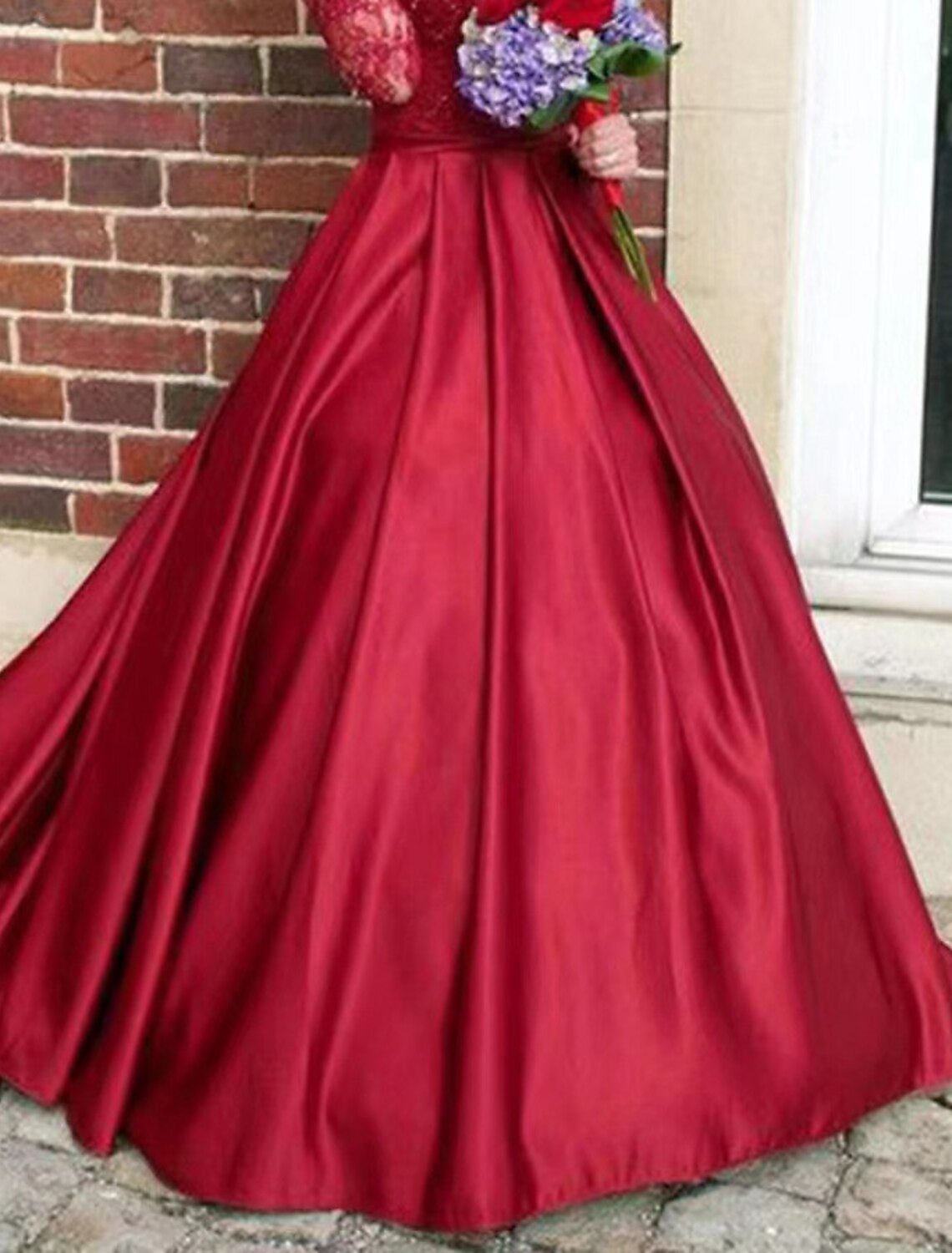 Close-up of the floral appliques on the long sleeve of the satin evening gown.