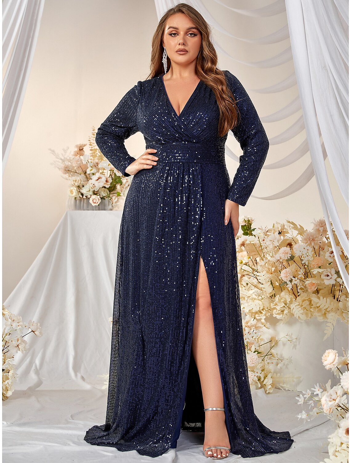 Full length view of an A-line evening gown with long sleeves and sequin details.