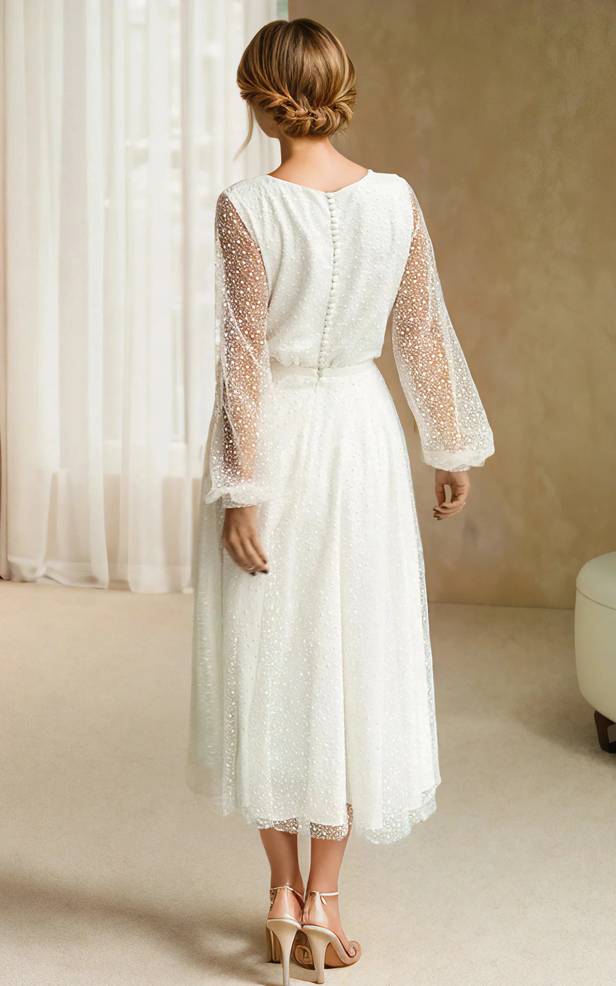 Back view of a woman in a white A-line tulle tea-length wedding dress.