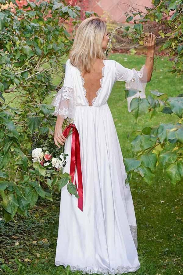 Back view of an A-line satin wedding dress showing lace accents and flowing train.