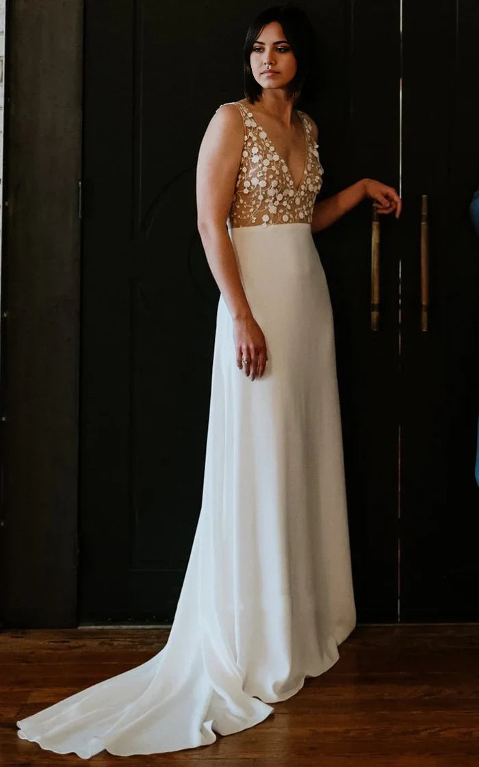 Full-length A-line bridal gown in satin, featuring a V-neckline and intricate applique details.
