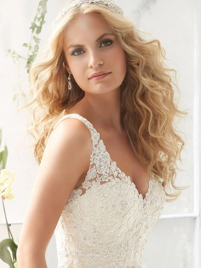 Side view of the V-neck lace wedding gown, showing the flowing court train.