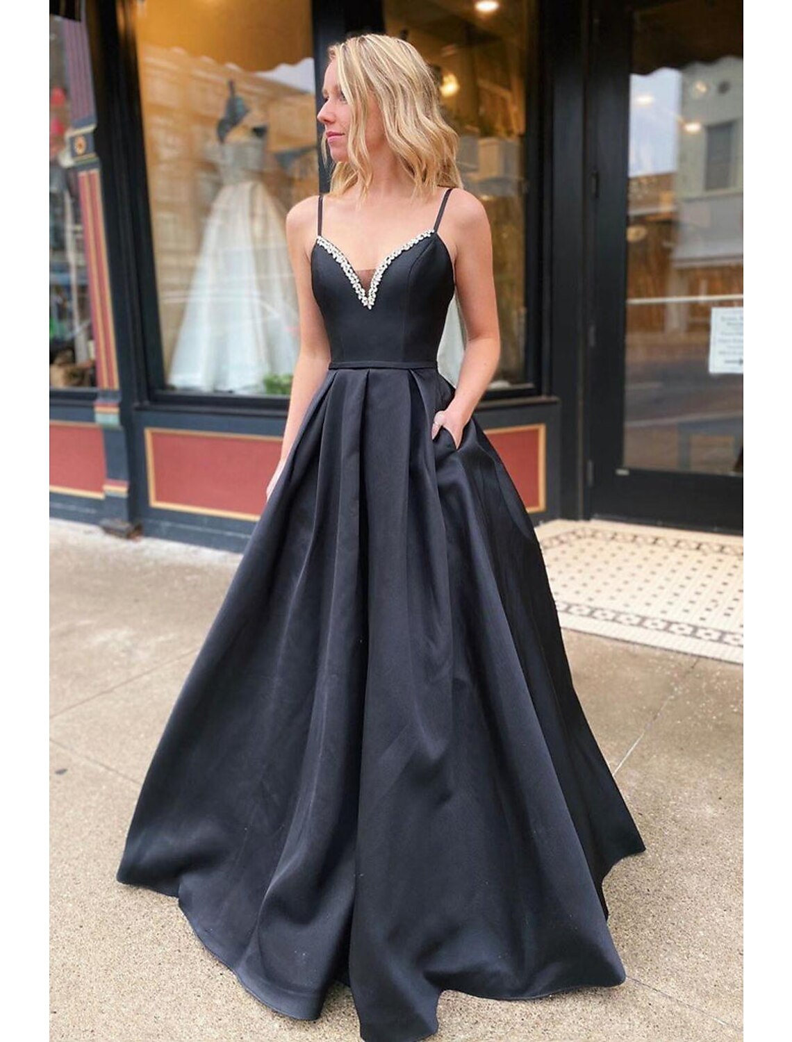 Model wearing an elegant A-line V-neck prom dress with an open back and pleats.