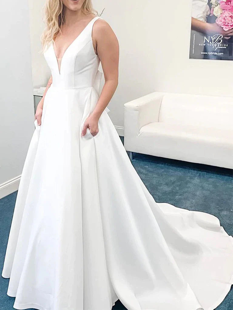 Elegant woman wearing a V-neck open back satin long prom dress with a flowing train.