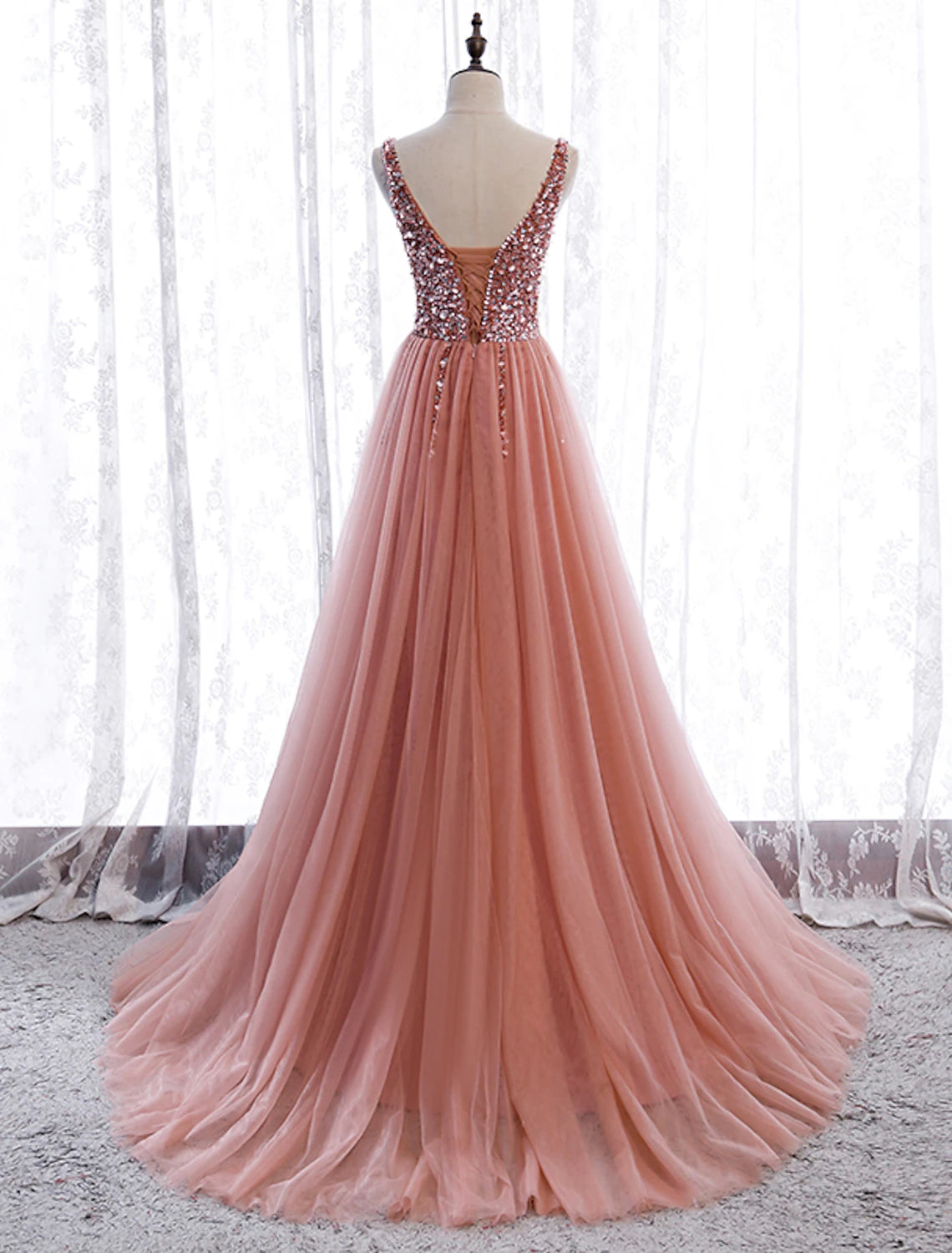 Back view of A-line prom dress showing court train and V-neckline.