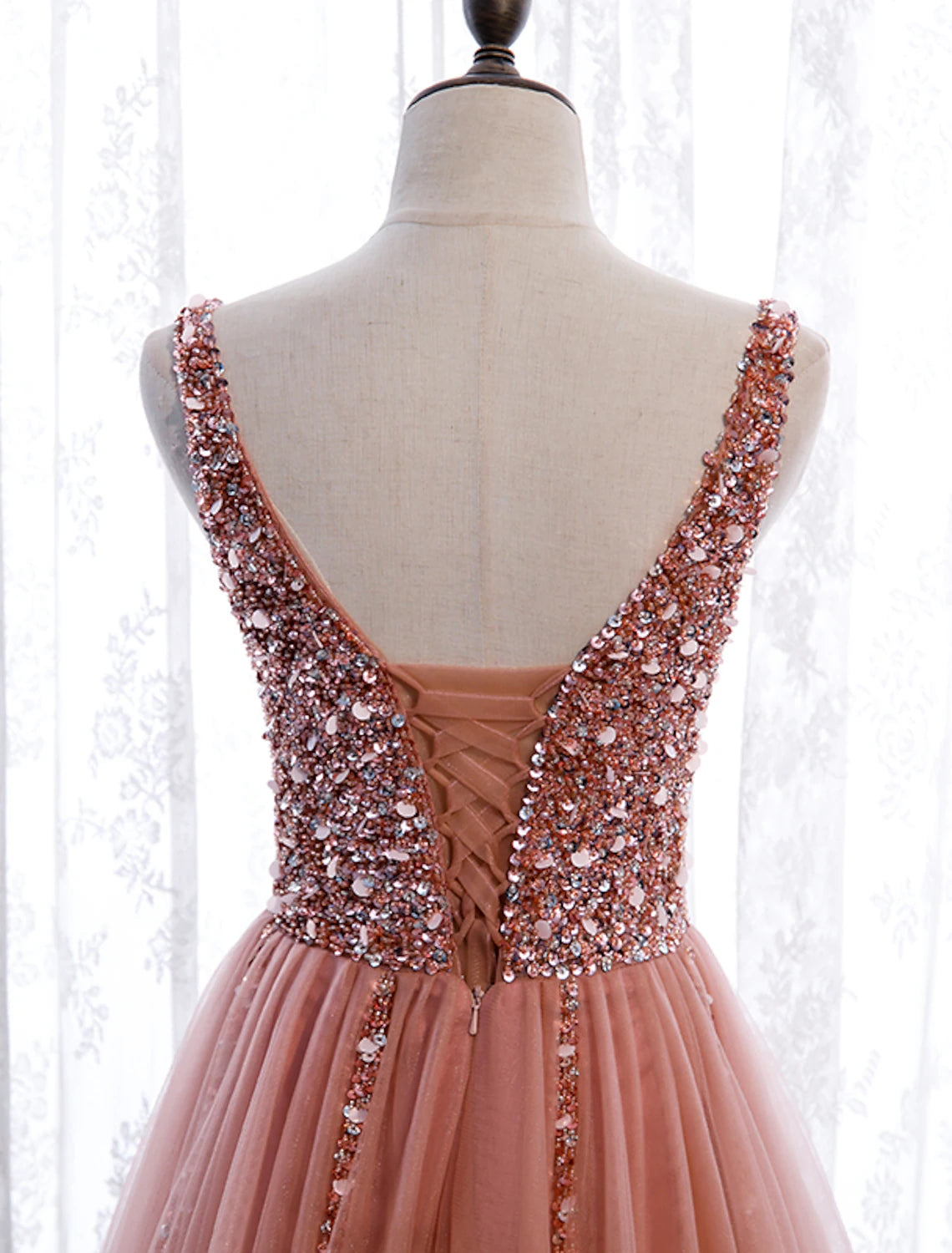 Side view of sleeveless A-line prom dress with pearl details.