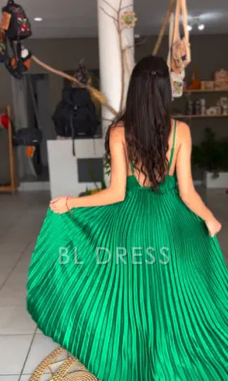Side view of a green A-line formal dress, highlighting the pleated details and flowing skirt.